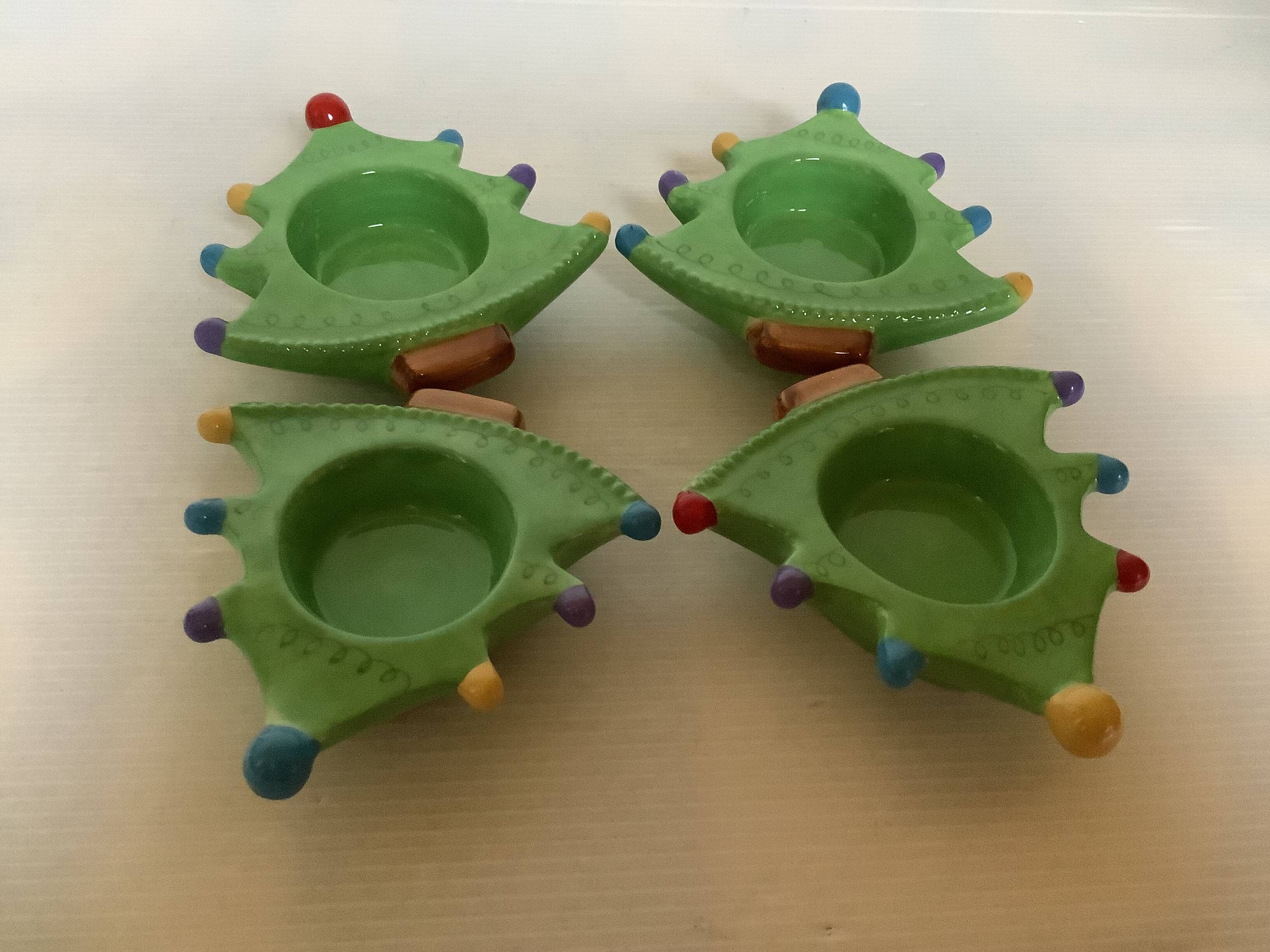 Four Christmas tree-shaped candle holders