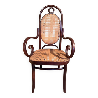 Curved wooden rattan armchair with caning from around 1900.