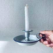 Old candle holder in white enameled metal