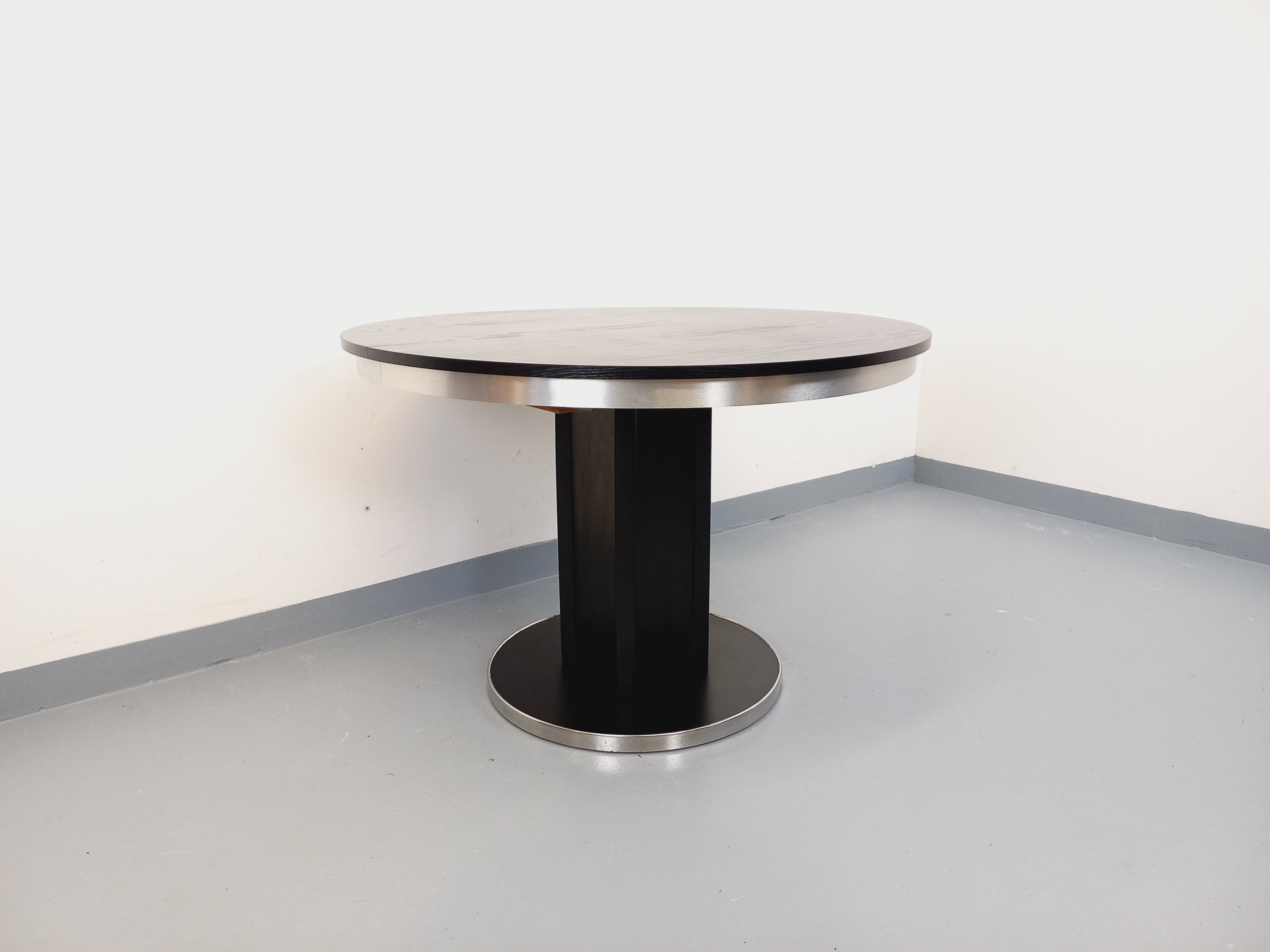 Vintage dining table in melamine with a black wood effect and chrome metal.