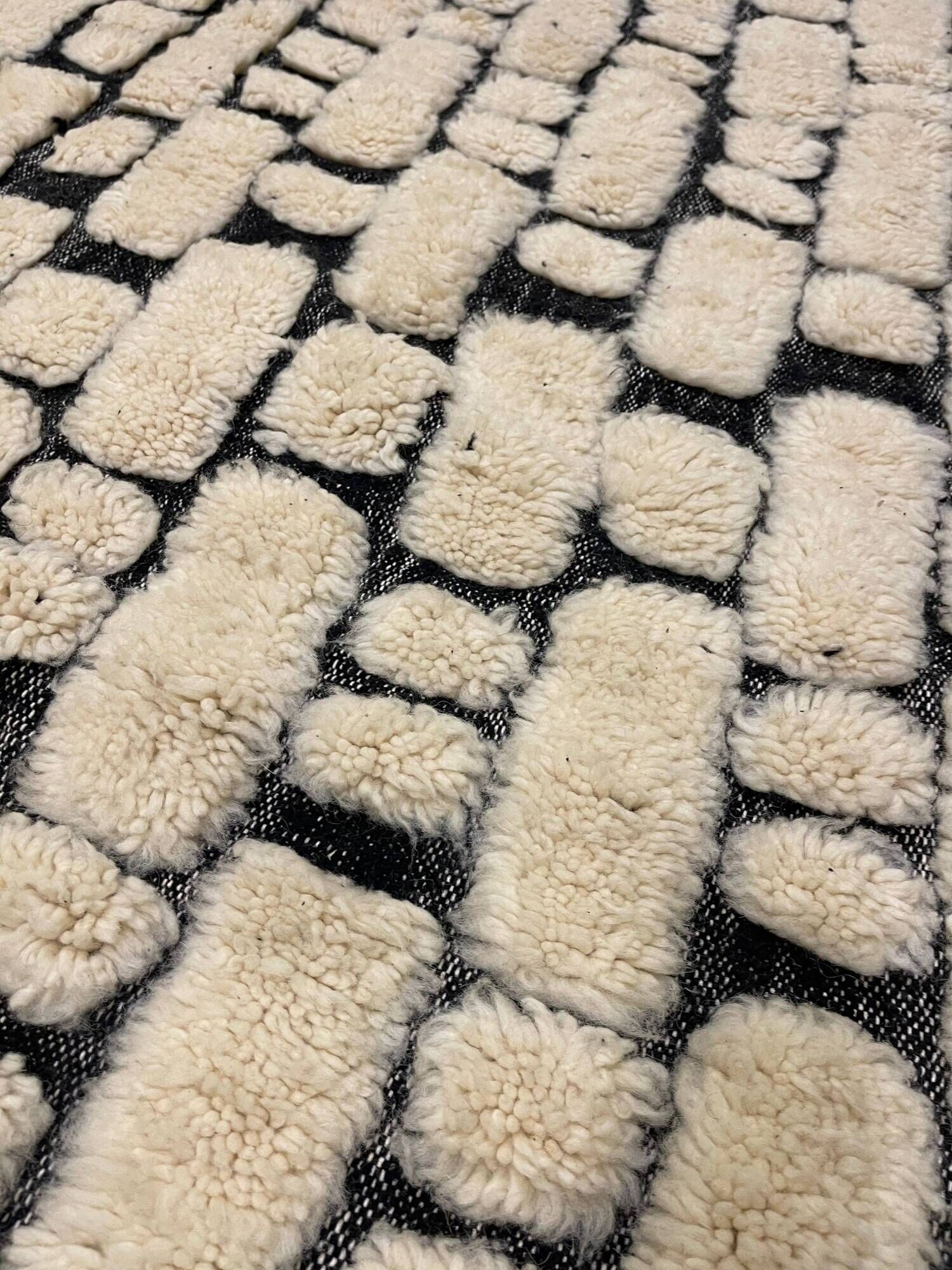 Large cream and black checked Berber rug, 280 × 200 cm.