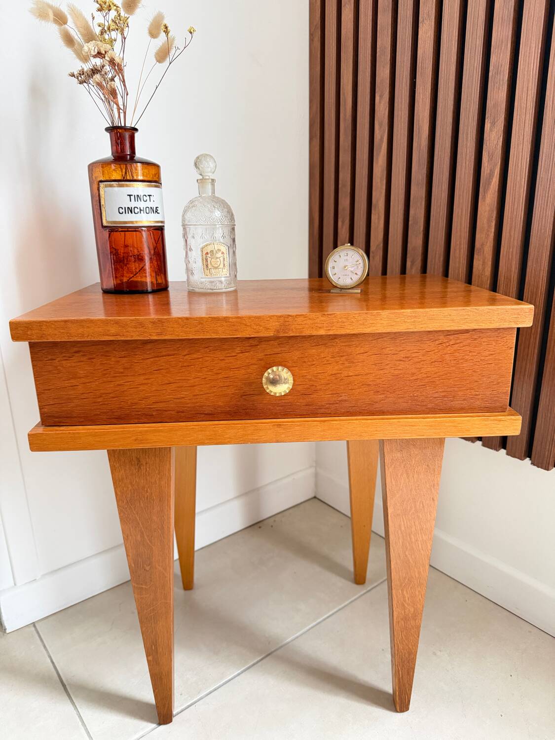 Vintage bedside table with tapered legs.