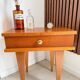 Vintage bedside table with tapered legs.