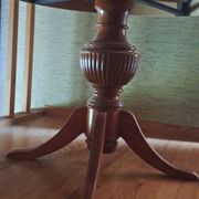 Round solid walnut table with central leg from the 1950s with extensions.