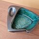 Ceramic ashtray with green and black glaze forming a pipe holder