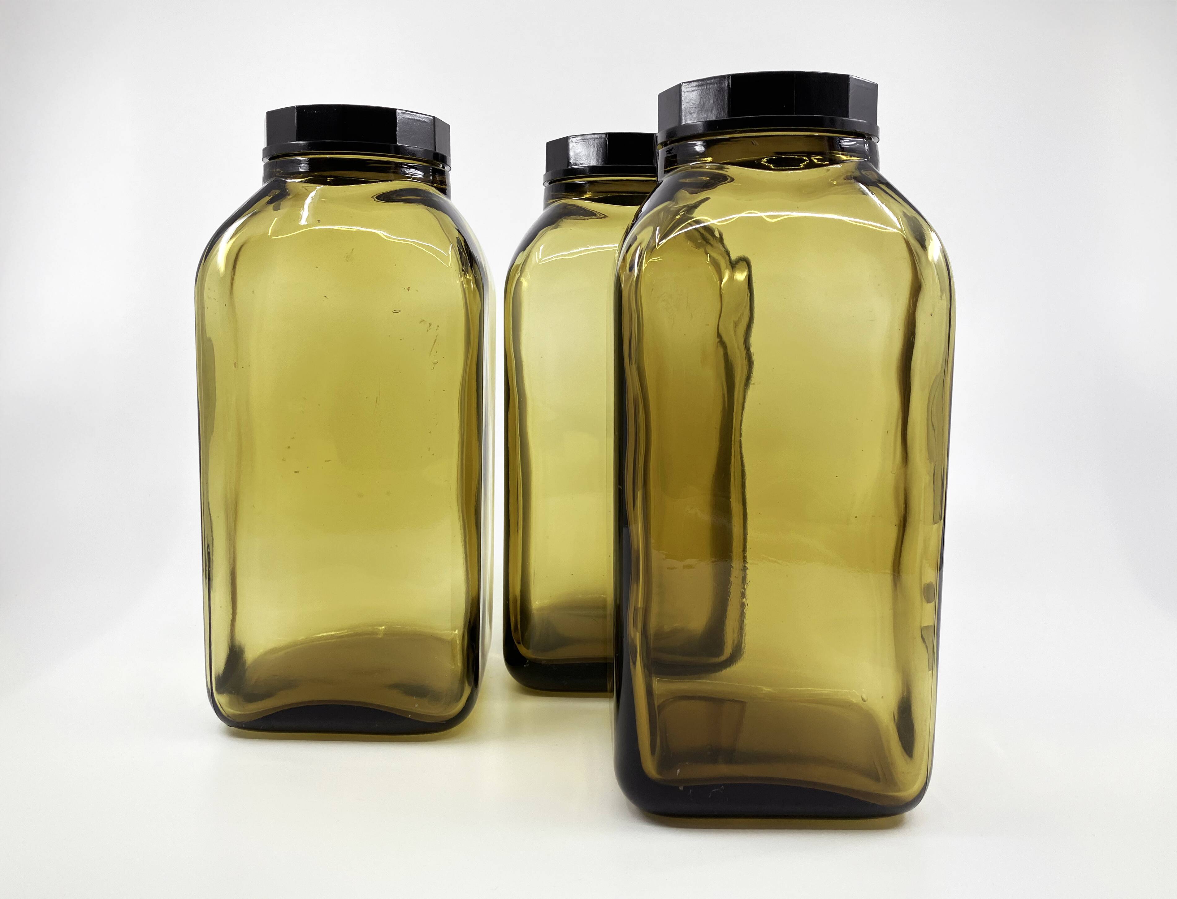 3 molded amber glass pharmacy bottles • Bakelite stoppers • 1950