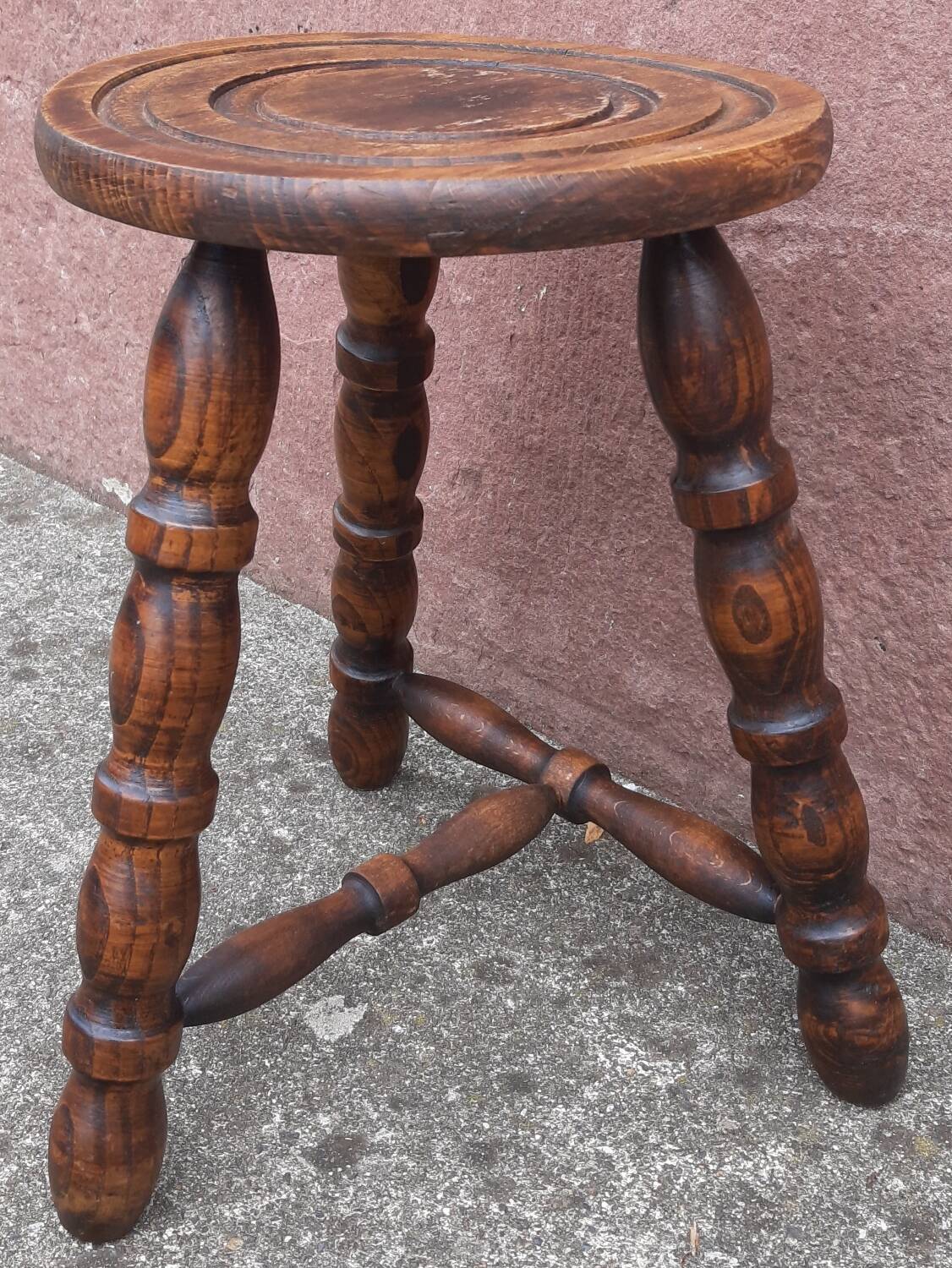 Low wooden tripod stool.