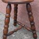 Low wooden tripod stool.