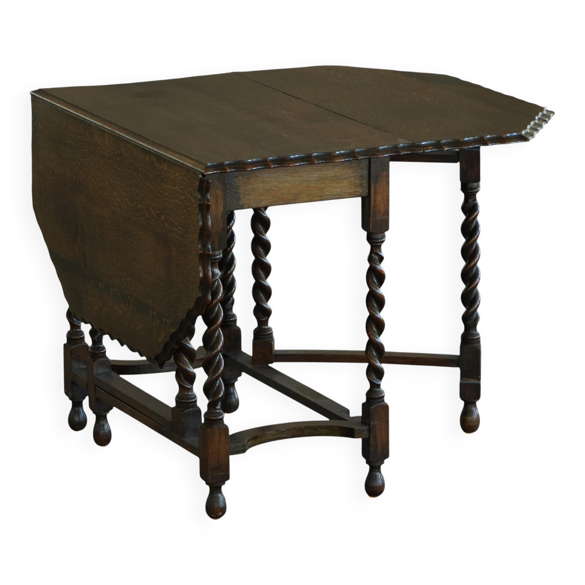 Antique baroque dining table in oak, with folding legs and drop leaves, featuring spiral "barley twist" legs, from the 1920s.