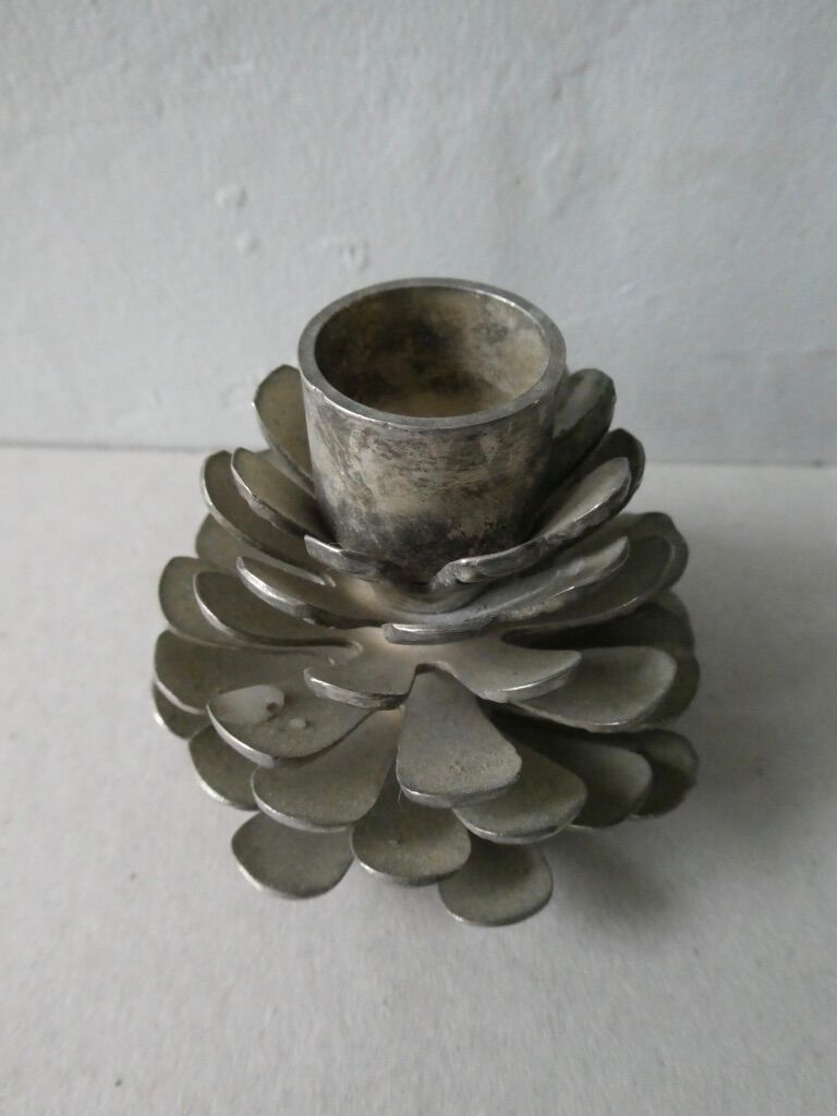Silver-coloured metal pine cone candlestick