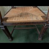Antique armchair in carved wood with a straw seat.