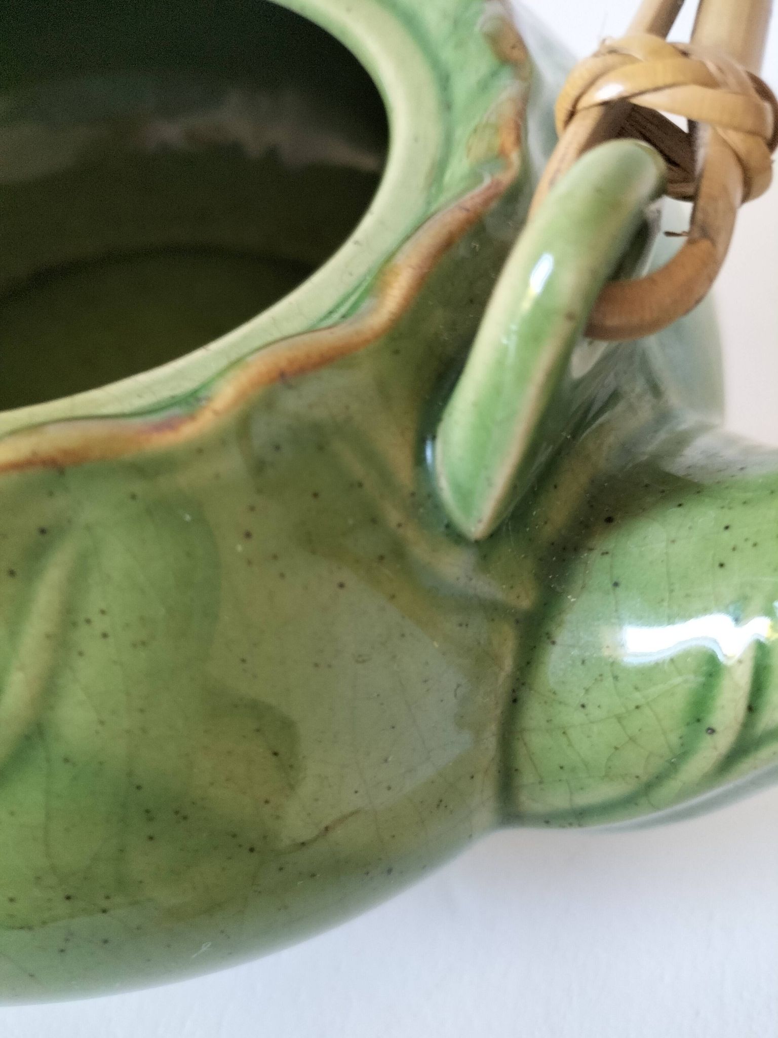 Vintage green teapot with lotus decoration and bamboo handle.