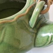 Vintage green teapot with lotus decoration and bamboo handle.
