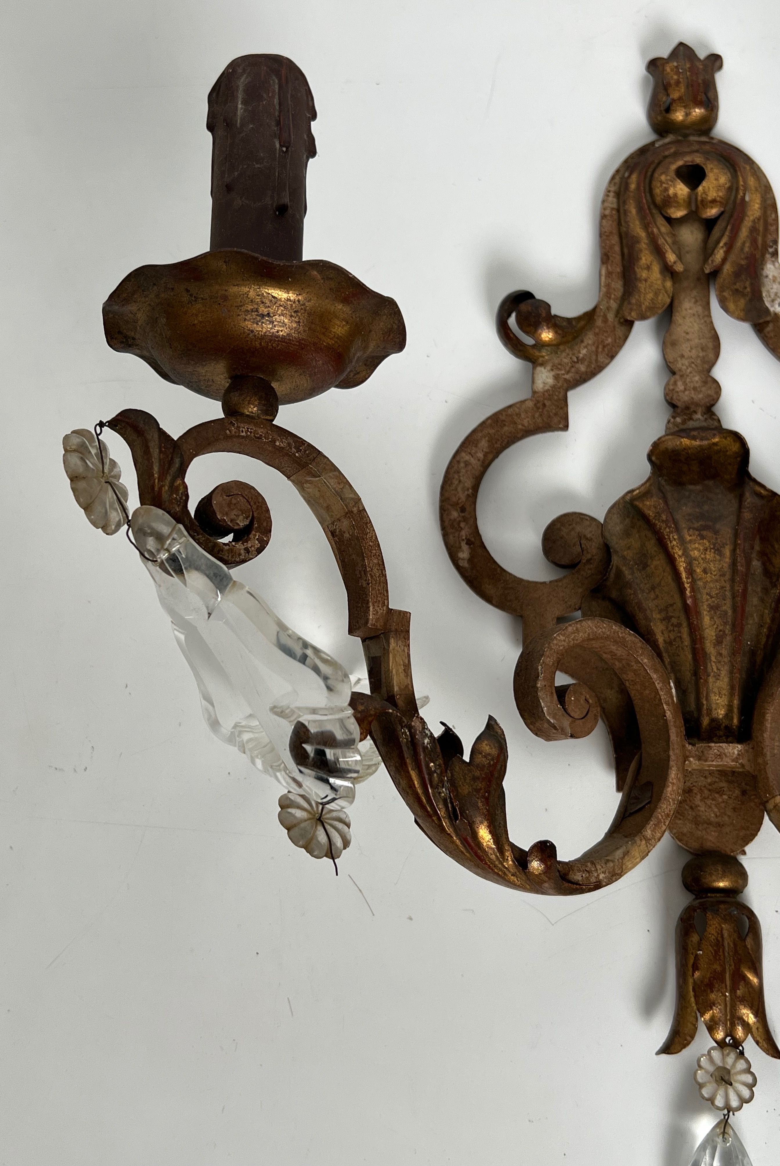Pair of patinated wrought iron wall sconces with golden acanthus leaves and crystals.