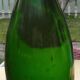 Green blown glass bottle of 58 cm.
