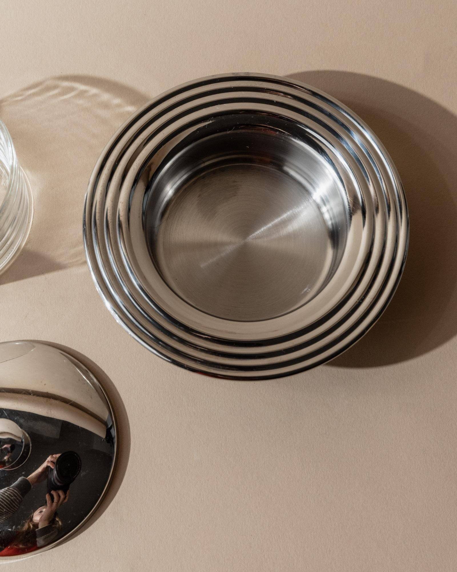 Vintage 1970s condiment pot made of glass and stainless steel with a lid, complete with a matching spoon.