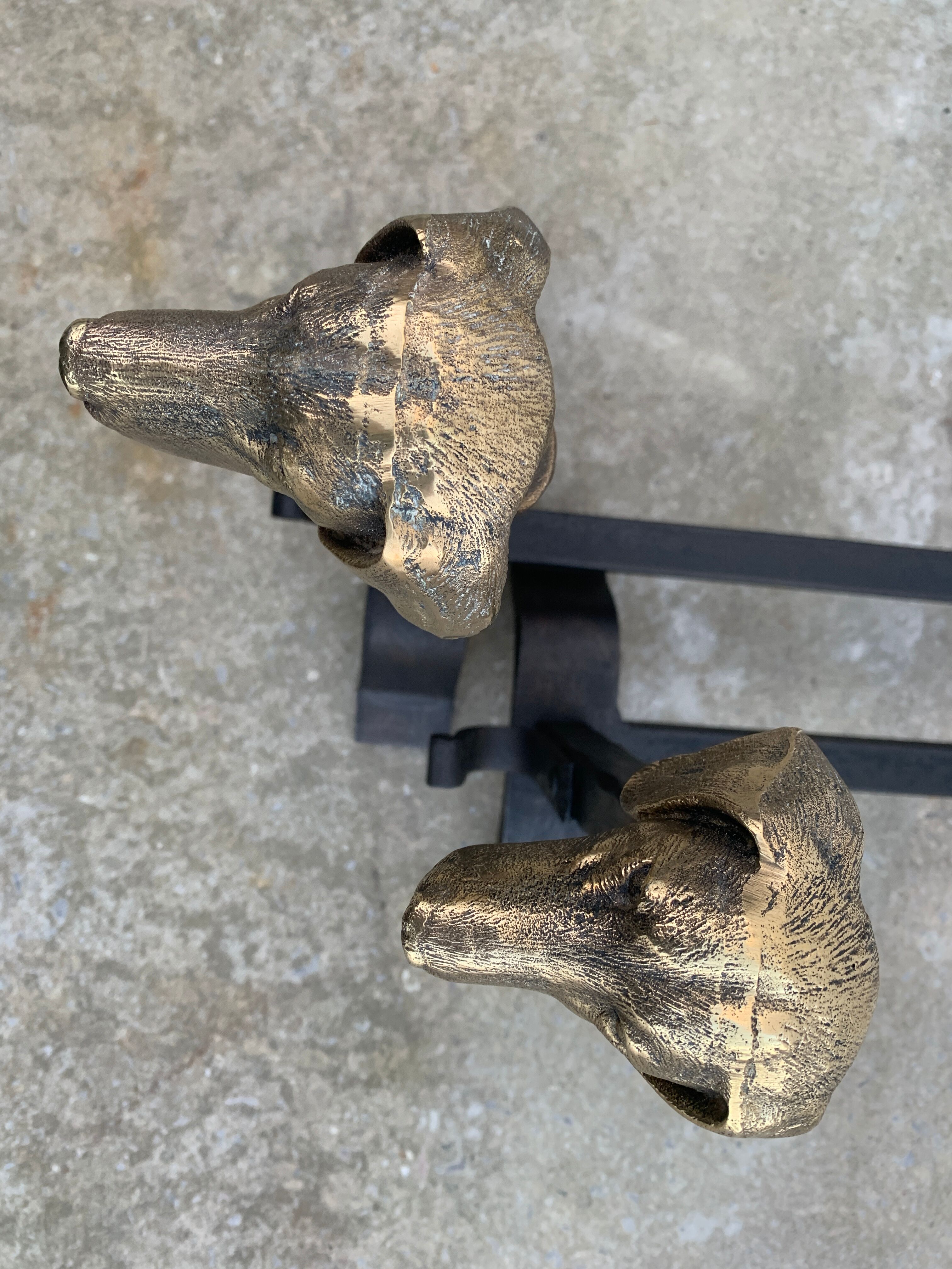 Pair of metal chenets decorated with brass dog heads