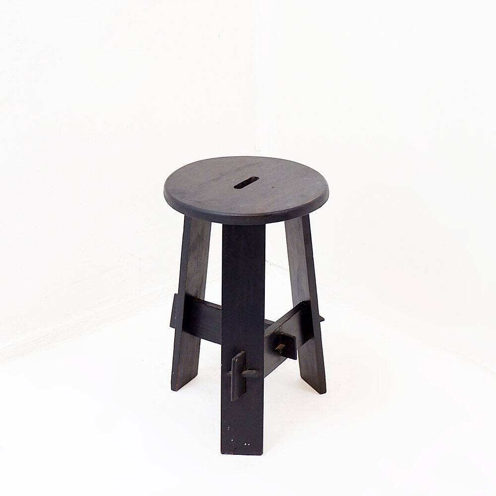 Vintage black-stained wooden tripod stool with mortise joints.