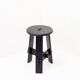 Vintage black-stained wooden tripod stool with mortise joints.