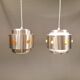 Two Space-Age hanging lamps, in silver-coloured aluminium with orange prisms.
