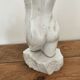 Sculpture of a female torso in white marble.