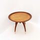 Round Art Deco side table in wood with curved legs and brass feet.