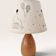 Wood-turned lamp with a hand-drawn lampshade, circus patterns.