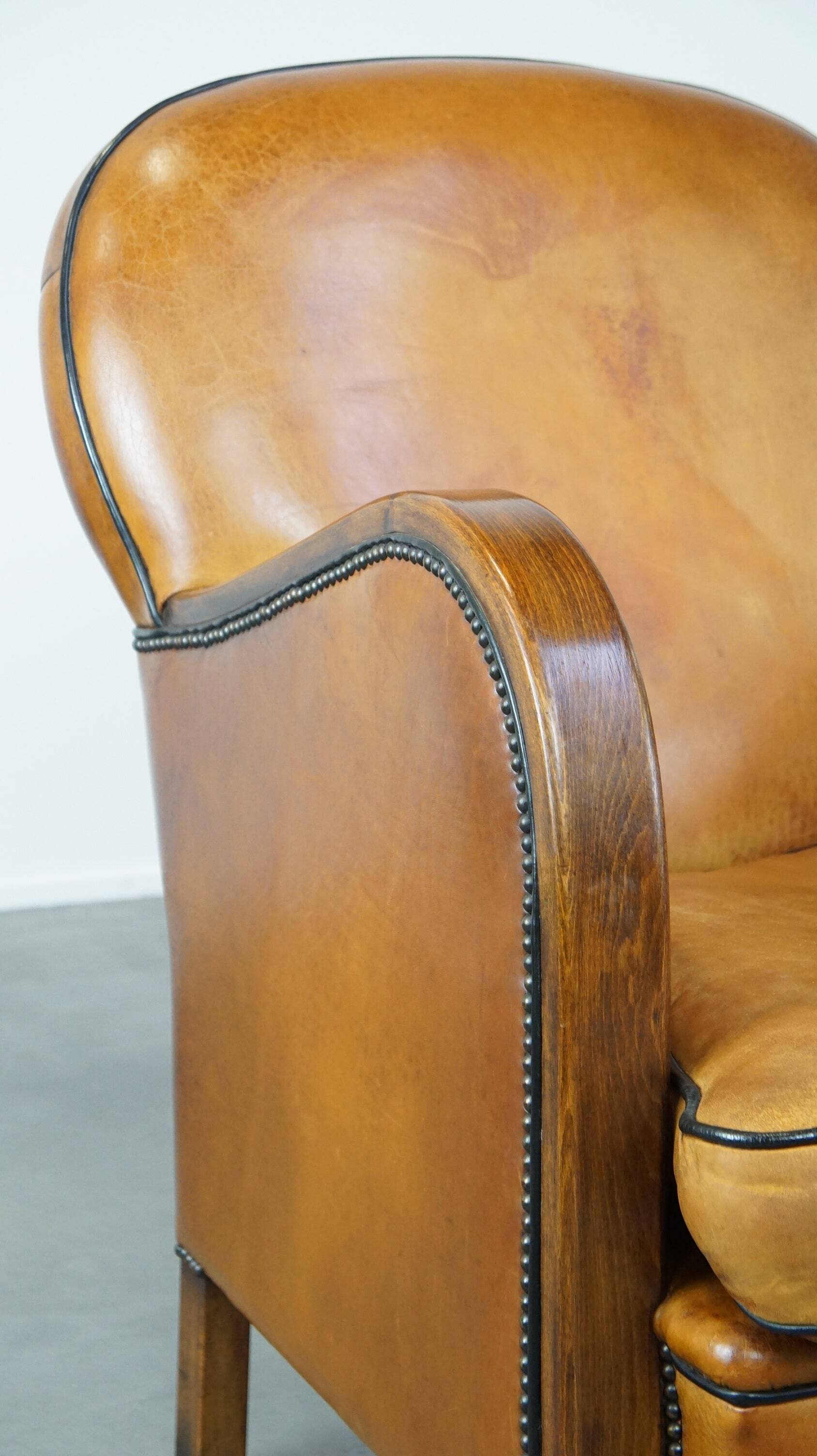 Unique, luxurious sheepskin armchair combined with wood and finished with decorative nails