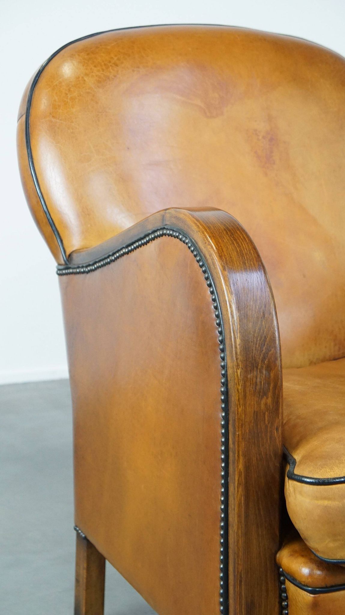 Unique, luxurious sheepskin armchair combined with wood and finished with decorative nails