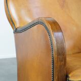 Unique, luxurious sheepskin armchair combined with wood and finished with decorative nails