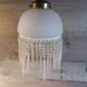 Brass swan neck wall lamp with pink glass globe and Charleston tassels