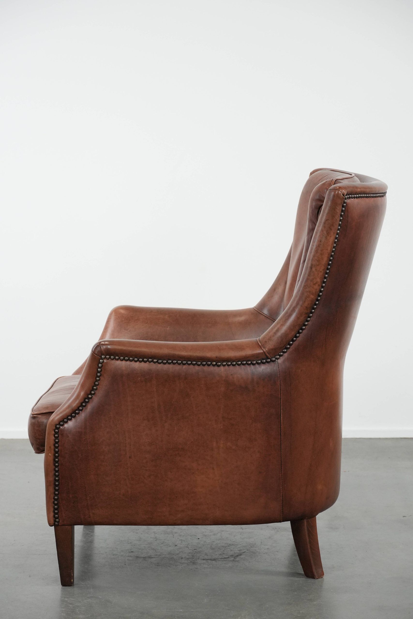 Cognac brown cow leather armchair with decorative nail finish