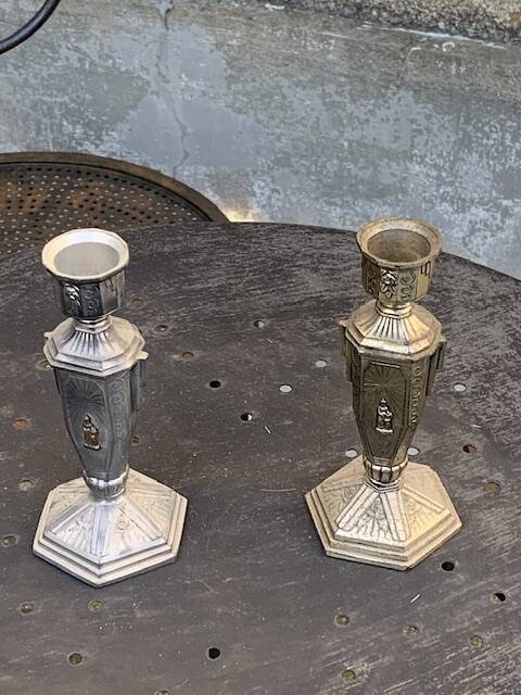 Pair of metal candlesticks, chiseled with a statuette in front, rose pattern in relief, art deco