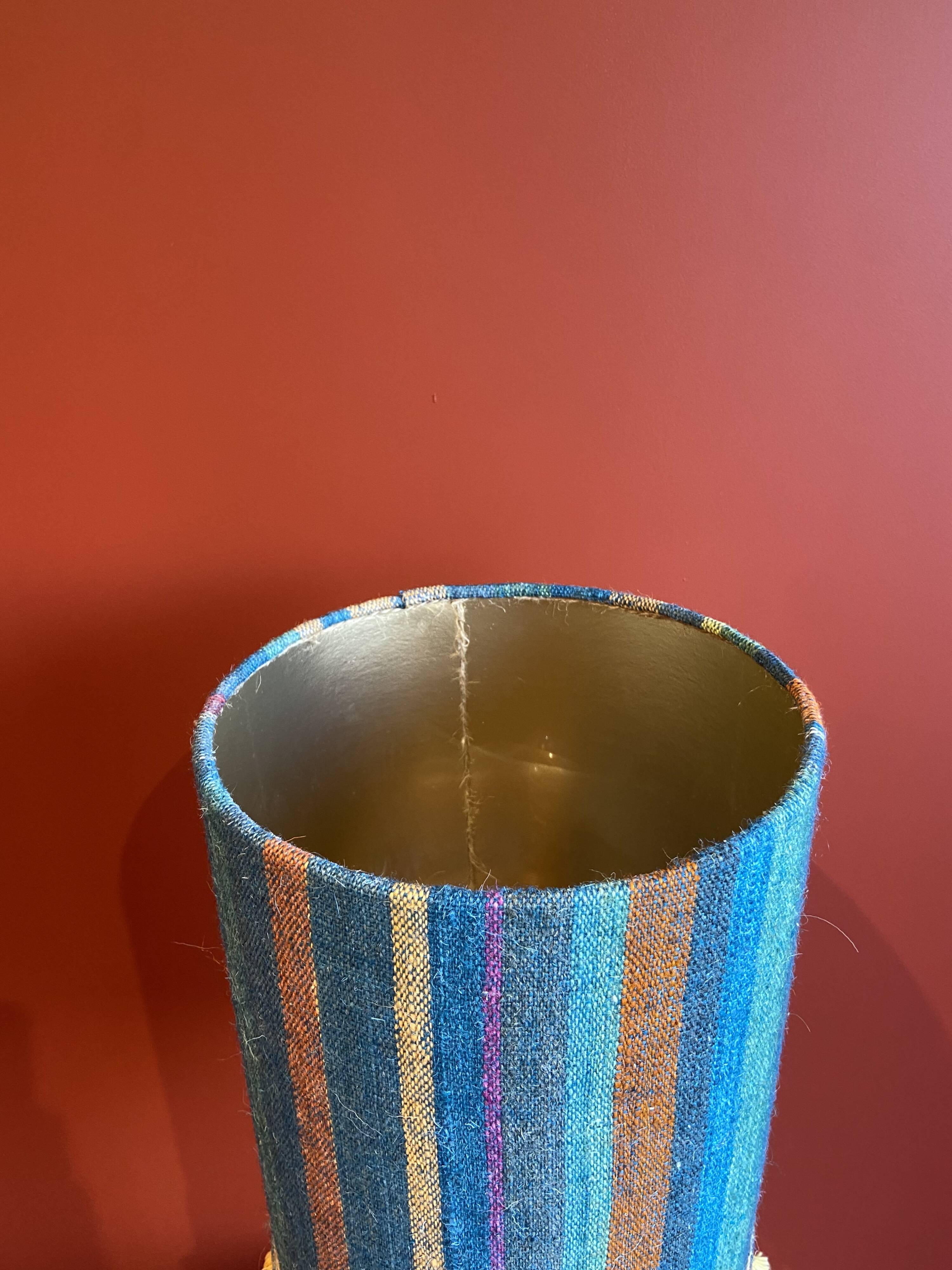 "Stoneware Bottle Lamp" with a multicoloured blue lampshade handwoven in India.