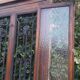 Oak entrance door and its frame and transom, wrought iron gates