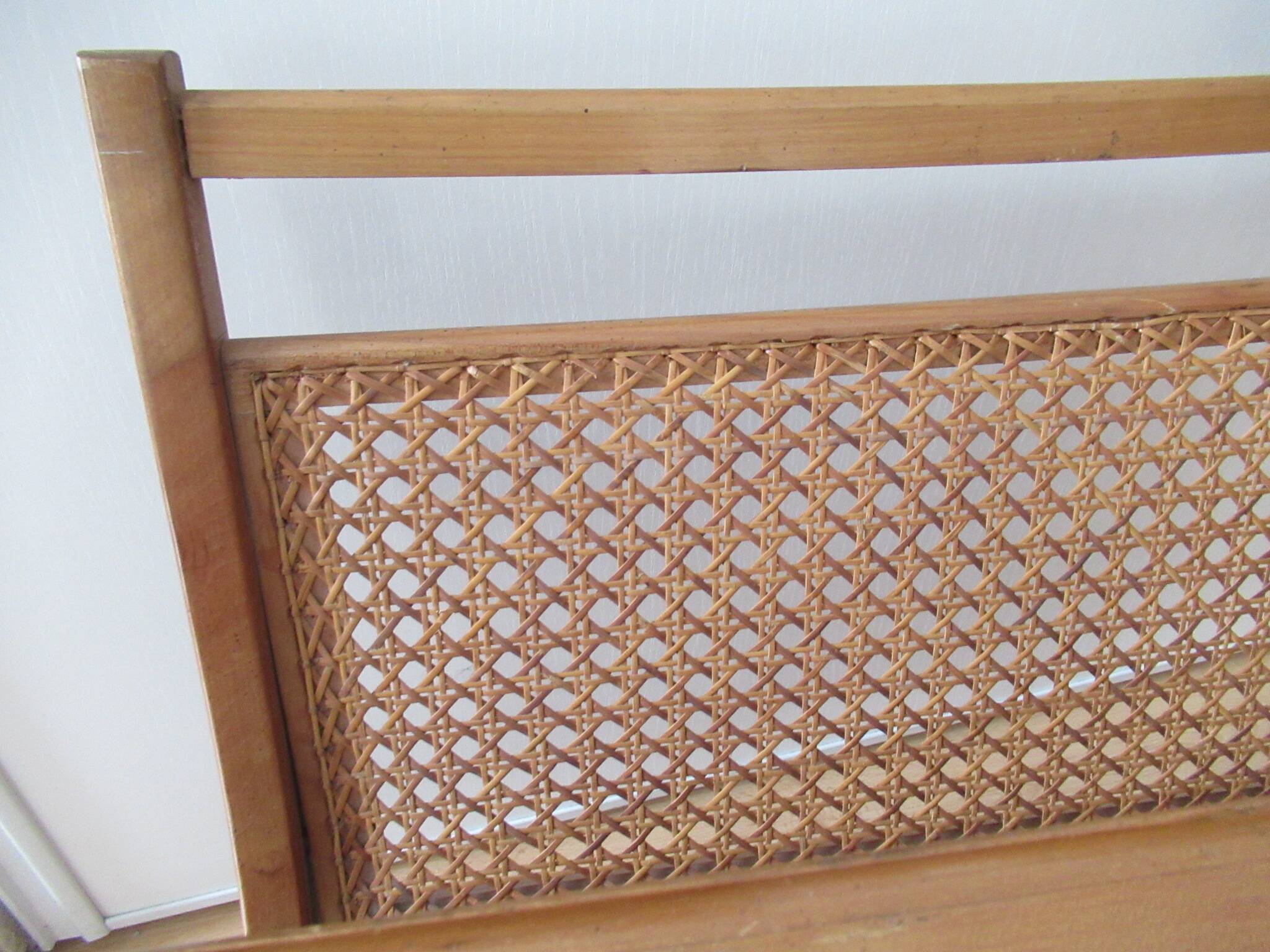 Cane magazine rack with light wood shelf