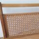 Cane magazine rack with light wood shelf