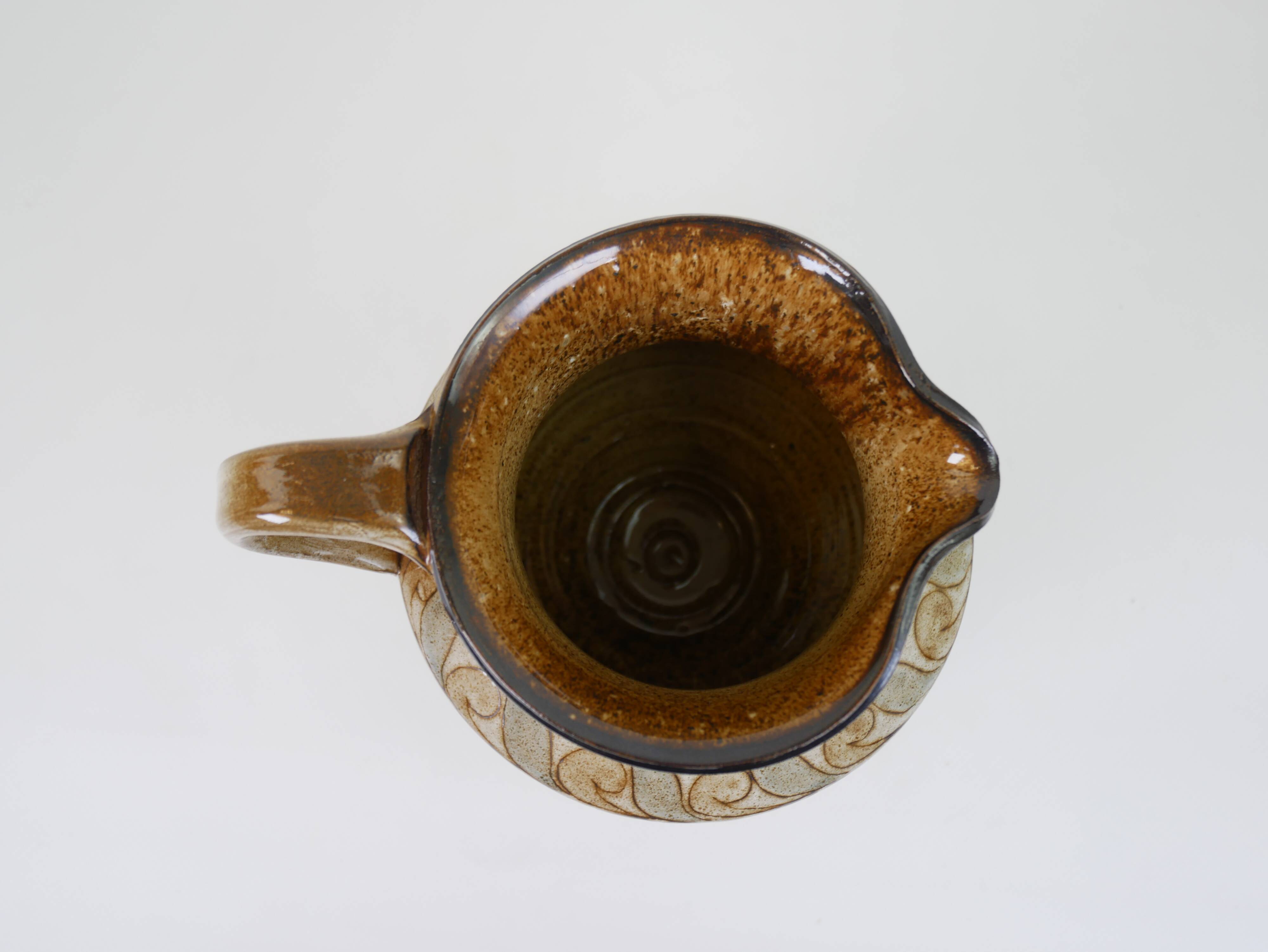 Glazed ceramic jug with plant decoration