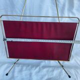 Vintage magazine rack in red skai with gold metal frame and plastic handle