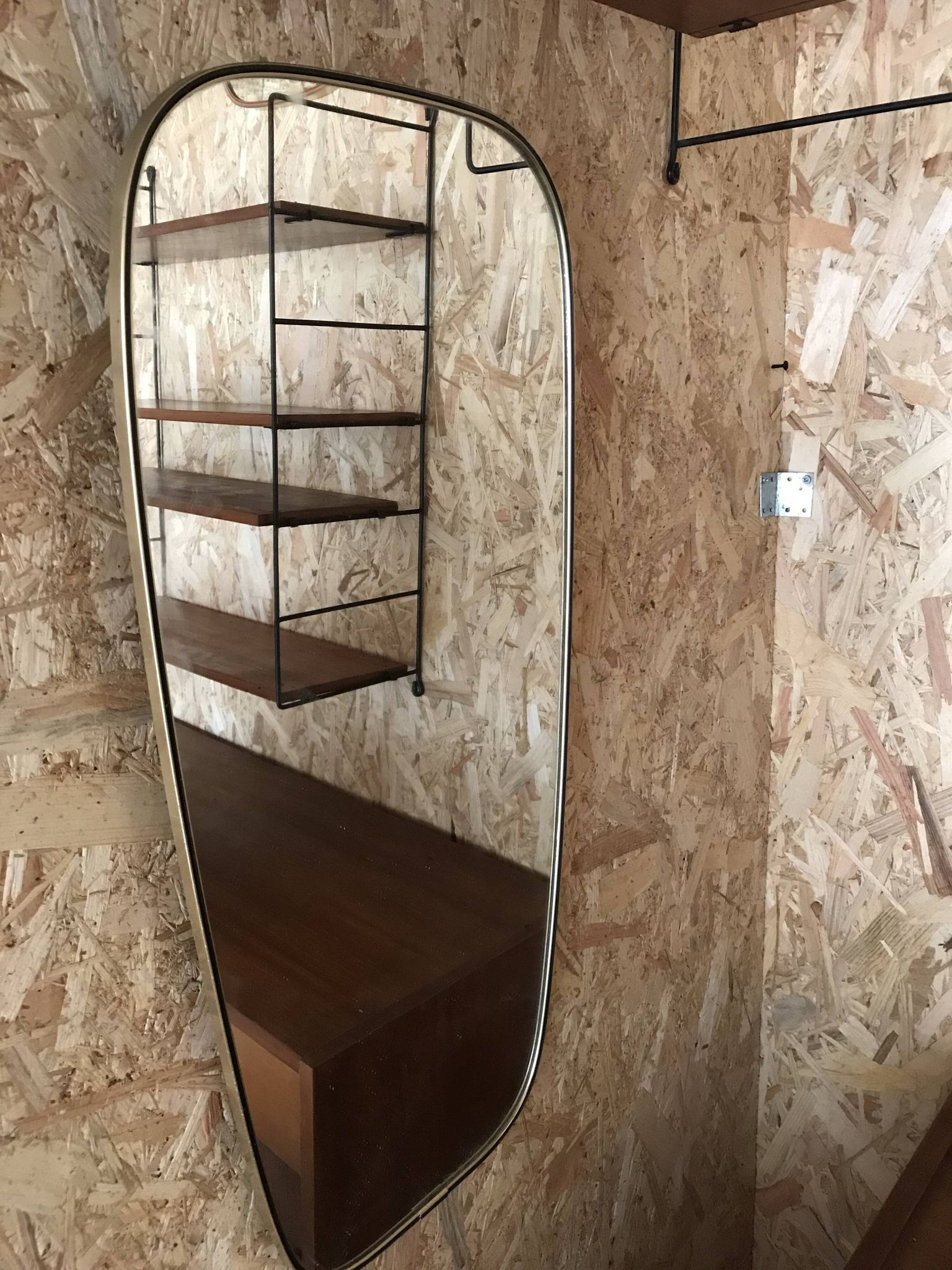 Vintage 1960 free-form mirror known as a retro mirror with a gold and black metal trim.