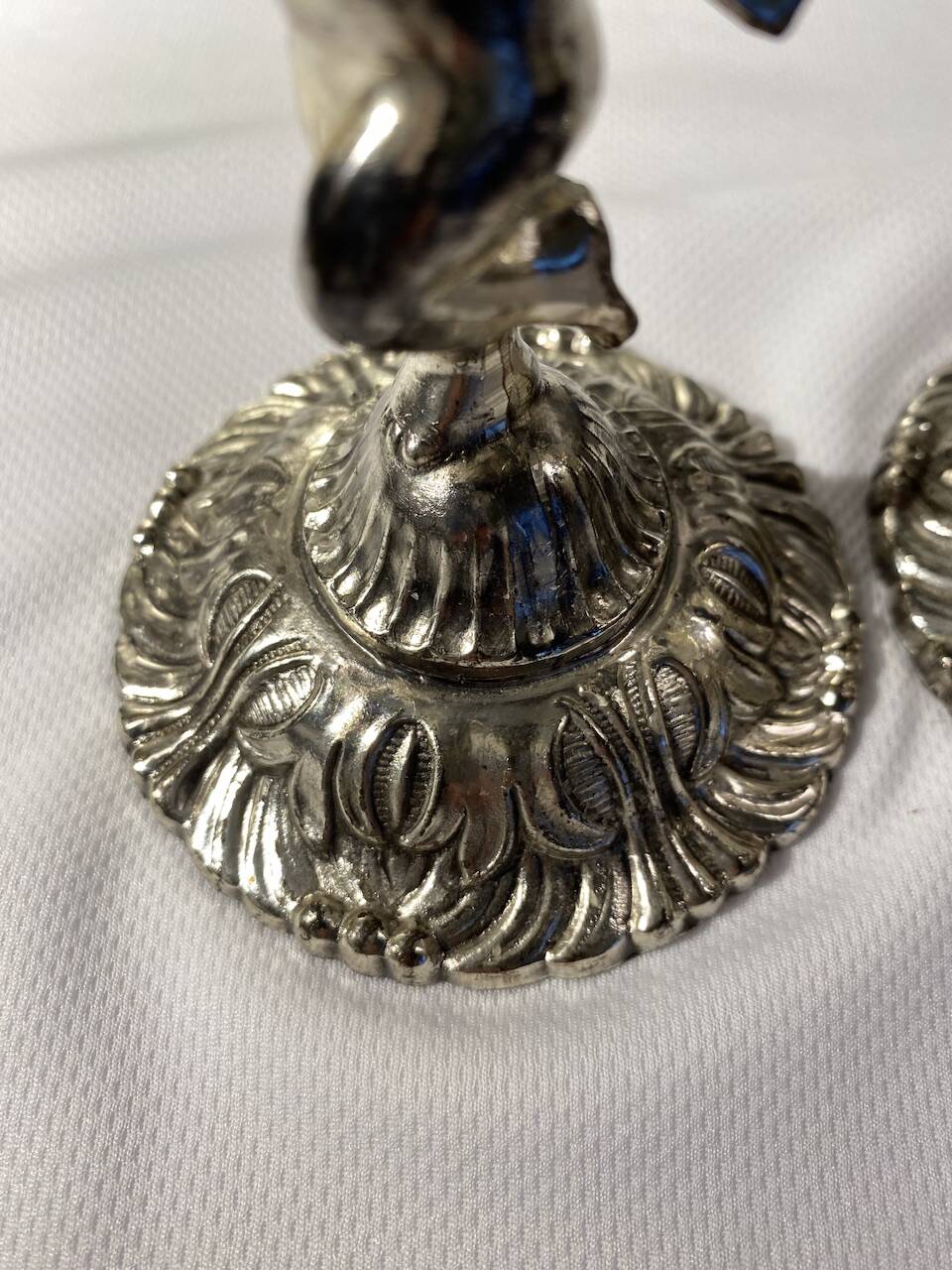 Two silver-plated metal candlesticks decorated with cherubs, 20th century