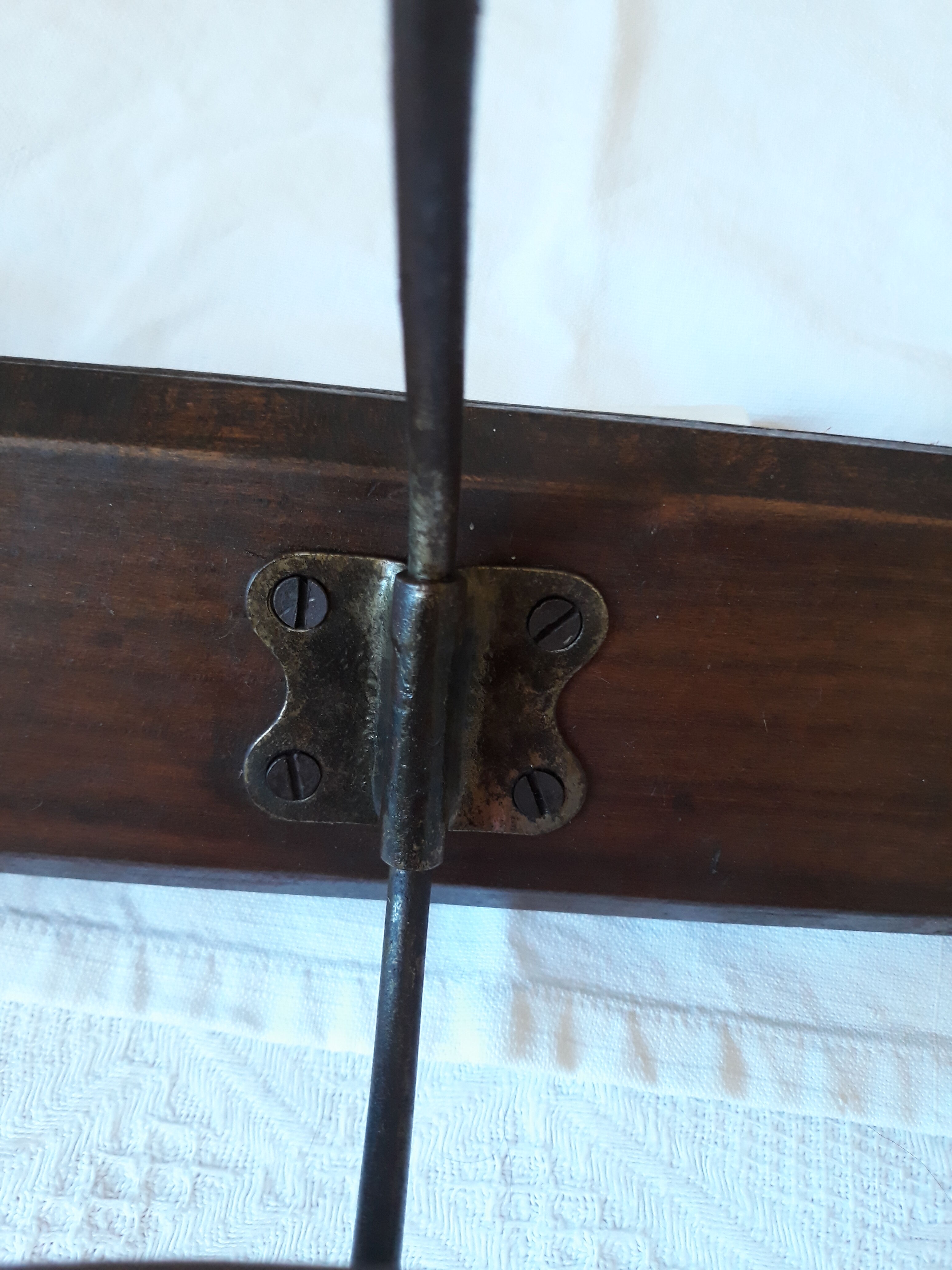 old wall coat holder made up of 3 wooden and metal pads.