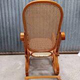 Curved wooden rocking chair with wicker cane rattan.