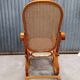 Curved wooden rocking chair with wicker cane rattan.