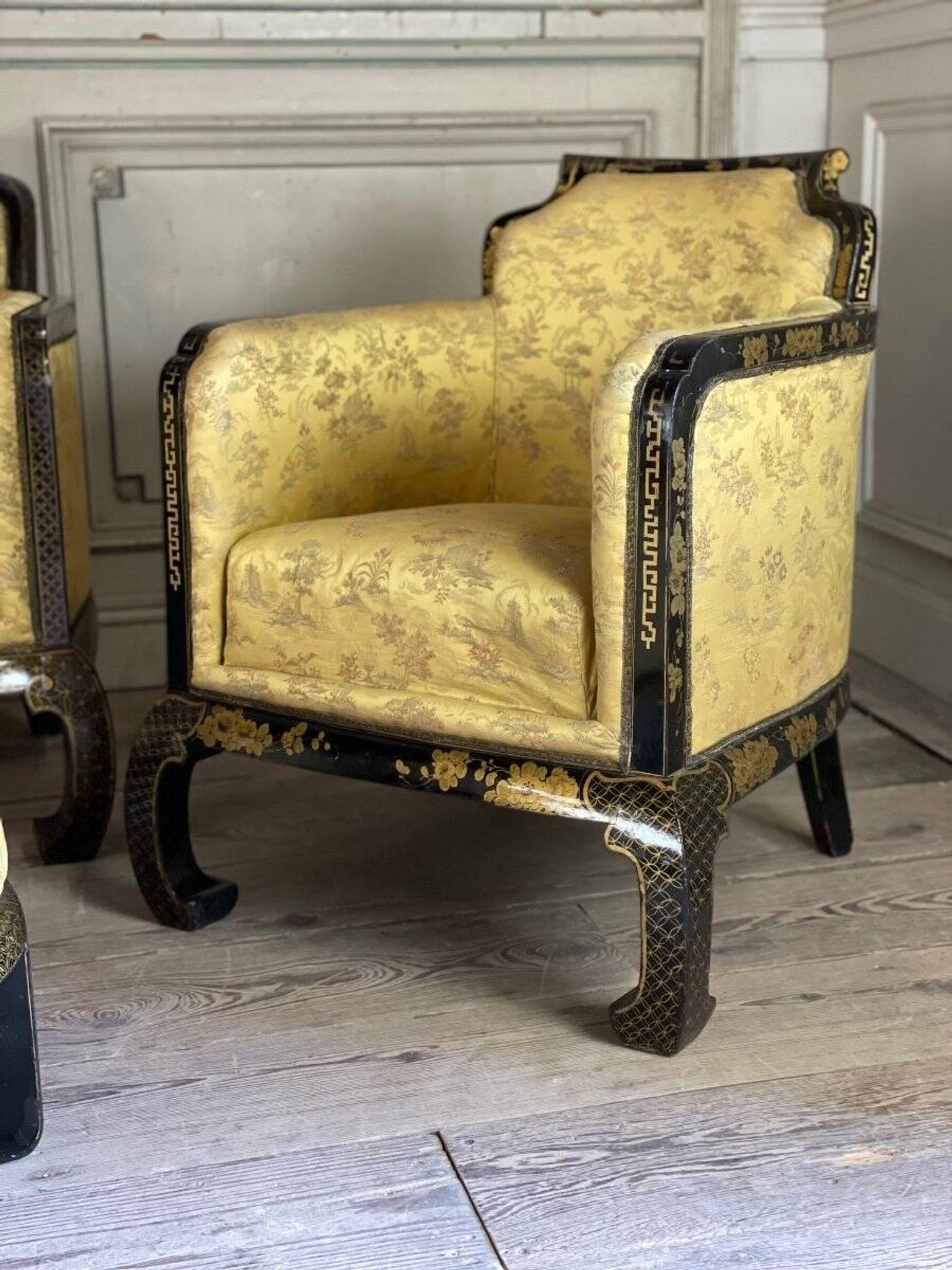A set of two armchairs, a sofa and two poufs in lacquered wood with gilded chinoiserie decoration.