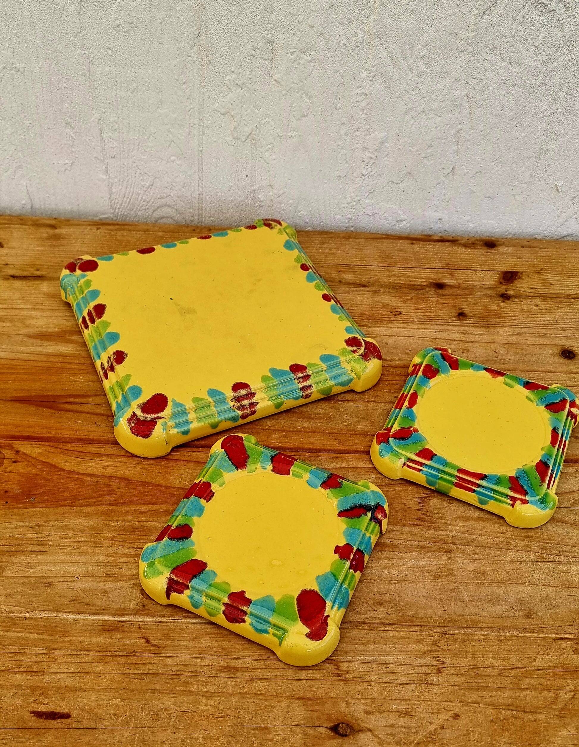 Yellow ceramic trivet and bottle coaster with vintage painted decoration.