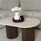 Oval coffee table in travertine and fluted wood.