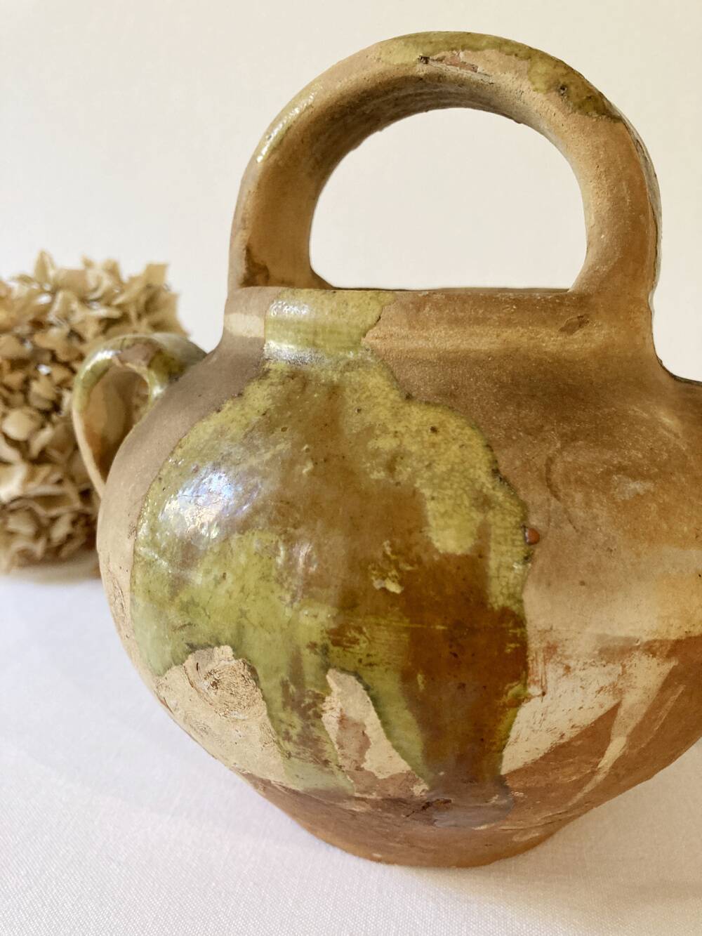 Small Provençal goat jug in creamy white and green enamelled stoneware