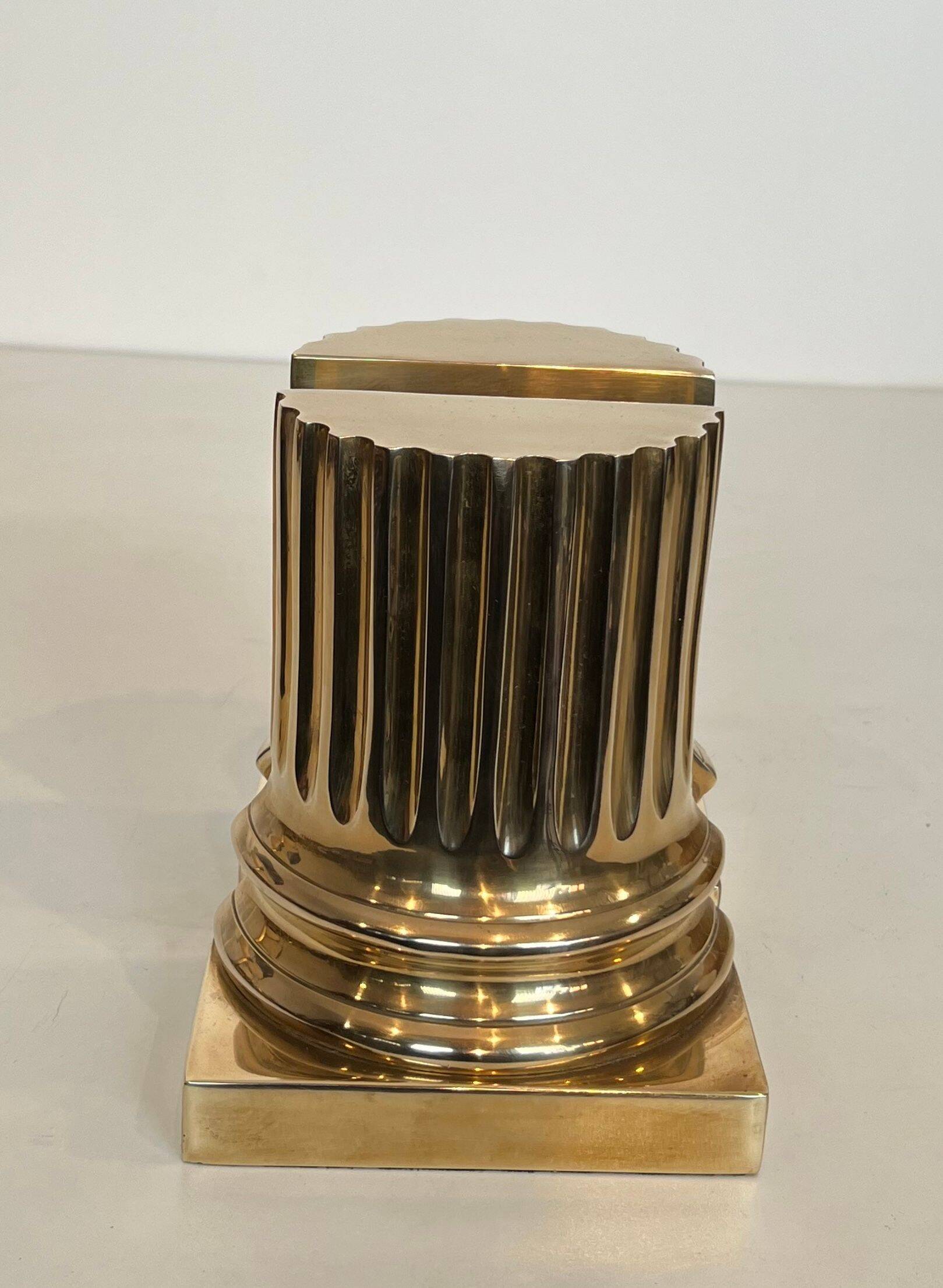 A pair of brass bookends representing columns.