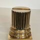A pair of brass bookends representing columns.